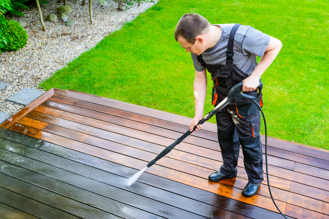 Professionnel SANIPRO nettoyant une terrasse pavée et une allée extérieure