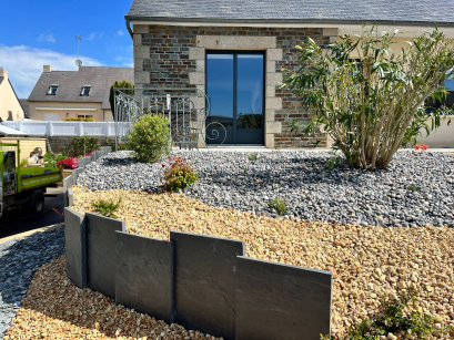 Retenue de terre avec palis de schiste scié, galets gris bleu, quartz et végétaux